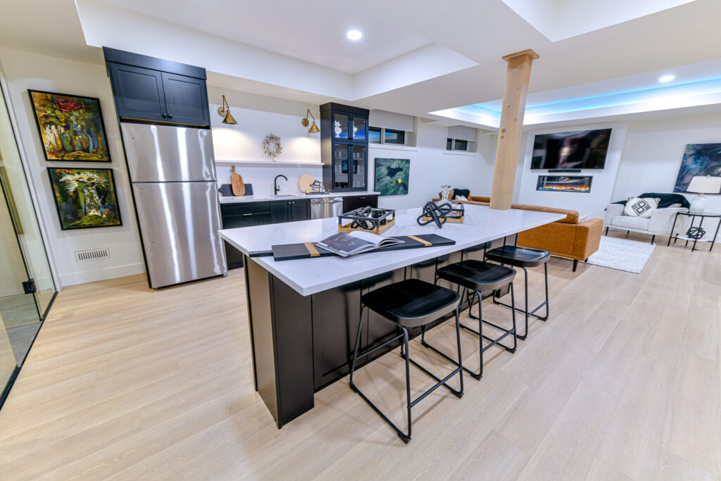Monarch Homes, signature style home, stylish kitchen, modern flooring and stools, fireplace with seating. Located in Grande Prairie, Alberta, Canada.